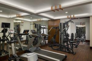 a gym with several tread machines and a mirror at The Fern Residency Ahmedabad, Subhash Bridge, Series by Marriott in Ahmedabad +4 photos