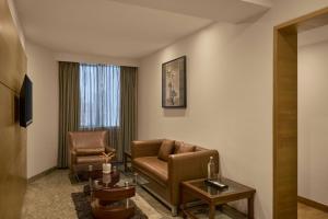 a living room with a couch and a chair at The Fern Residency Ahmedabad, Subhash Bridge, Series by Marriott in Ahmedabad