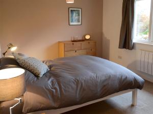 a bedroom with a bed with a dresser and a window at Morlich in Gairloch