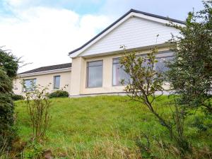 a house with a grass yard in front of it at Morlich in Gairloch