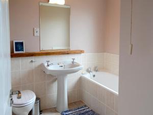 a bathroom with a sink and a tub and a toilet at Morlich in Gairloch +7 photos