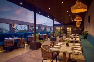 a restaurant with tables and chairs and a large window at The Fern Residency, Solapur, Series by Marriott in Solapur