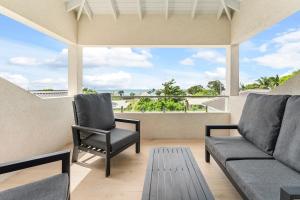 a living room with a couch and a chair at Mullins Bay View - 4 Bed - Sea View, Infinity Pool in Saint Peter