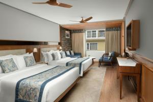 a hotel room with two beds and a desk at The Fern Brentwood Resort, Mussoorie, Series by Marriott in Mussoorie +19 photos