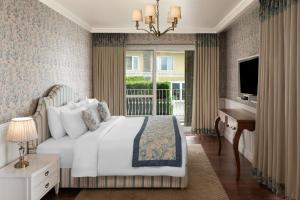 a bedroom with a bed and a desk and a window at The Fern Brentwood Resort, Mussoorie, Series by Marriott in Mussoorie