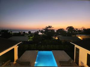 a view of a swimming pool at sunset at Mullins Bay View - 4 Bed - Sea View, Infinity Pool in Saint Peter