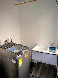a small kitchen with a sink and a water heater at Amazon Luxury Loft 201 in Florencia