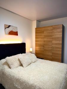 a bedroom with a large white bed and wooden cabinets at Amazon Luxury Loft 201 in Florencia +10 photos