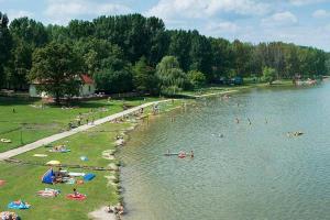 a group of people swimming in a lake at Easy Sleep - Comfy Stay in Soltvadkert