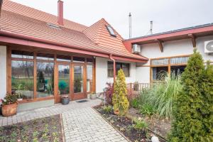a house with glass doors and plants in a yard at Easy Sleep - Comfy Stay in Soltvadkert