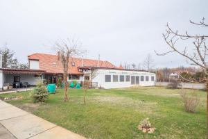 a house with a yard with a building at Easy Sleep - Comfy Stay in Soltvadkert