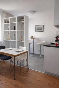 a kitchen and dining room with a table and chairs at Central & Tranquil by Cathedral in Fribourg +5 photos