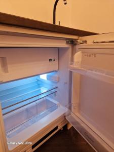 an empty refrigerator with its door open in a kitchen at Kaunas Studios - RentA 18 in Kaunas