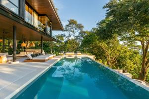 an infinity pool in the backyard of a house at Tenowi Villa in Mal País