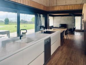 a kitchen with a sink and a large window at Casa Anjana in Rubayo