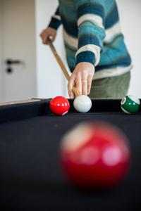 a woman playing a game of pool with a cue at Raposa Verde - Agroturismo in Pegarinhos