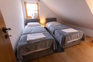 two beds in a small room with a window at Timber Home in Veliko Trgovišće