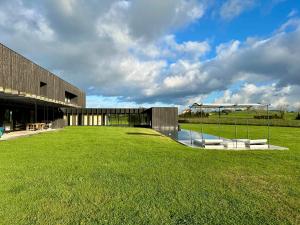 a building with a grassy field in front of it at Casa Anjana in Rubayo