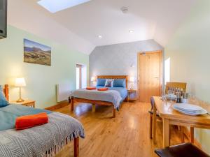 a bedroom with a bed and a table and a table sidx sidx sidx at Quinag Studio Apartment - Uk49098 in Inchnadamph