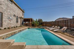 a swimming pool with lounge chairs next to a building at 5Br Lux! Pool, Games & Theater in Rowlett