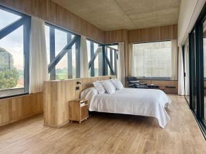 a bedroom with a large bed and large windows at Casa Anjana in Rubayo +38 photos