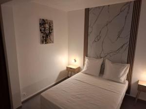 a bedroom with a white bed with two night stands at Le Chalet d'Ajoupa in LʼAjoupa-Bouillon +10 photos