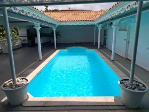 a swimming pool on the back of a house at Le Chalet d'Ajoupa in LʼAjoupa-Bouillon