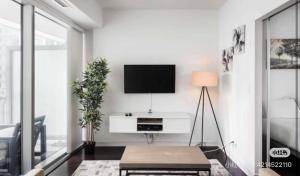 a living room with a tv on a white wall at Pine Breeze in Markham