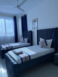 two beds in a room with blue lighting at Nyali Vale residence-14 in Mombasa