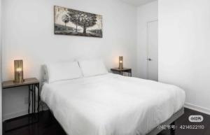 a bedroom with a white bed and two night stands at Pine Breeze in Markham
