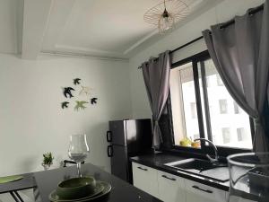 a kitchen with a sink and a window with bats on the wall at Cerises in El Aouina Station