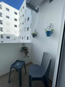 a chair and a stool in a room with a building at Cerises in El Aouina Station