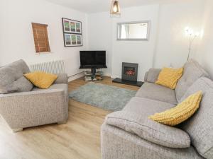 a living room with two couches and a tv at Win Hill View in Bamford