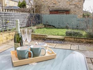 a table with a bottle of wine and a glass at Win Hill View in Bamford