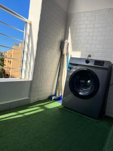 a washing machine on a balcony with a green carpet at Nyali Vale residence-14 in Mombasa +5 photos