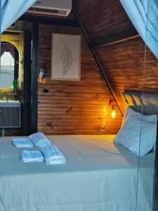 a bedroom with a bed with two towels on it at 2205 Chalé Suíte Pousada CadClube in Sao Jose do Rio Preto