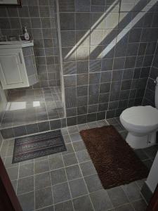 a bathroom with a toilet and a tile floor at Kaye Jacquot in Monchy