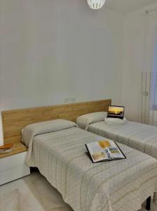 two beds in a bedroom with a laptop on top at Casa di Ale in Rapallo