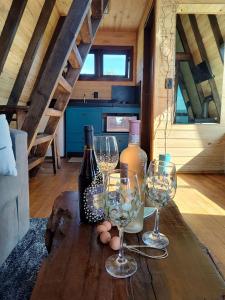 a table with two wine glasses and a bottle of wine at Pousada Colina do Sol in Urubici