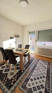 a dining room with a table and chairs on a rug at Guest House Bosnian House in Sarajevo