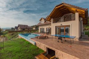 a house with a wooden deck with a pool at Jezerska Villa in Ogulin