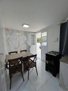 a kitchen with a table and chairs and a stove at PARAISO A BEIRA Mar de Antunes, conforto,Piscina,Mar e Natureza in Maragogi