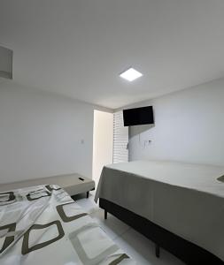 a bedroom with a bed and a tv on the wall at PARAISO A BEIRA Mar de Antunes, conforto,Piscina,Mar e Natureza in Maragogi