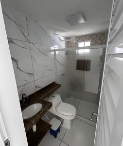 a white bathroom with a toilet and a sink at PARAISO A BEIRA Mar de Antunes, conforto,Piscina,Mar e Natureza in Maragogi +38 photos