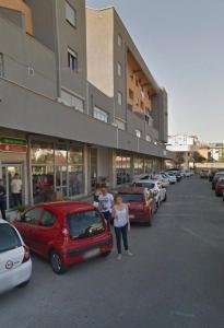 two people standing in a parking lot next to cars at Stex Urban 3 in Podgorica