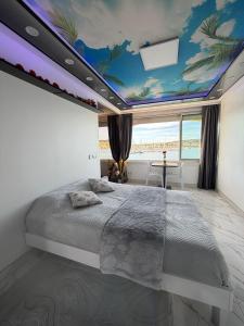 a bedroom with a large bed with a painting on the ceiling at 240 Magnifique Appart Deluxe vue mer in Cap d'Agde