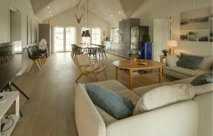 a living room with a couch and a table at Nice Home In Grenaa With Sauna in Grenå