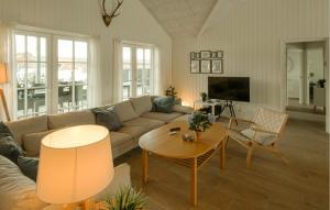a living room with a couch and a table at Nice Home In Grenaa With Sauna in Grenå
