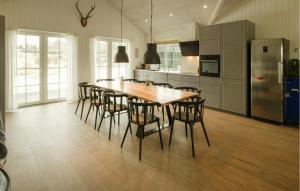 a kitchen with a long wooden table and chairs at Nice Home In Grenaa With Sauna in Grenå