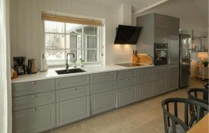 a large kitchen with a sink and a window at Nice Home In Grenaa With Sauna in Grenå
